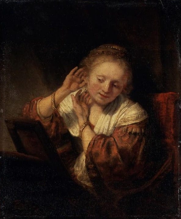 Jeune femme essayant des boucles d’oreilles – Rembrandt van Rijn Rembrandt van Rijn